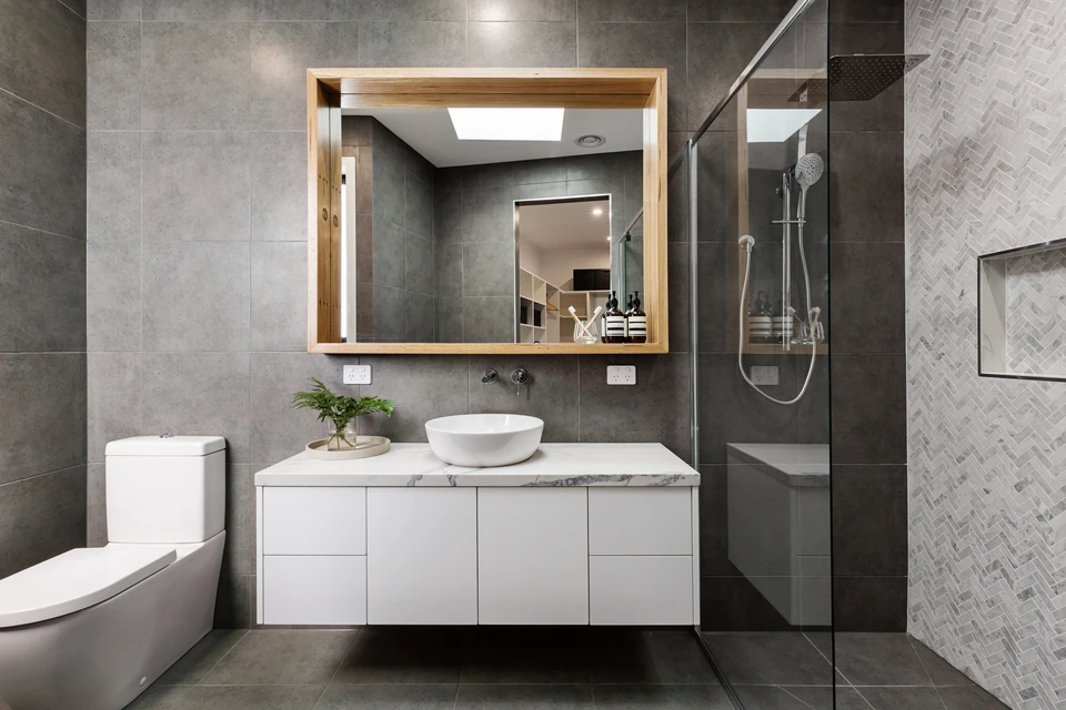 Salle de bain moderne avec douche à l'italienne, meuble vasque suspendu blanc, vasque à poser ronde, miroir encadré bois avec éclairage LED intégré, WC suspendu