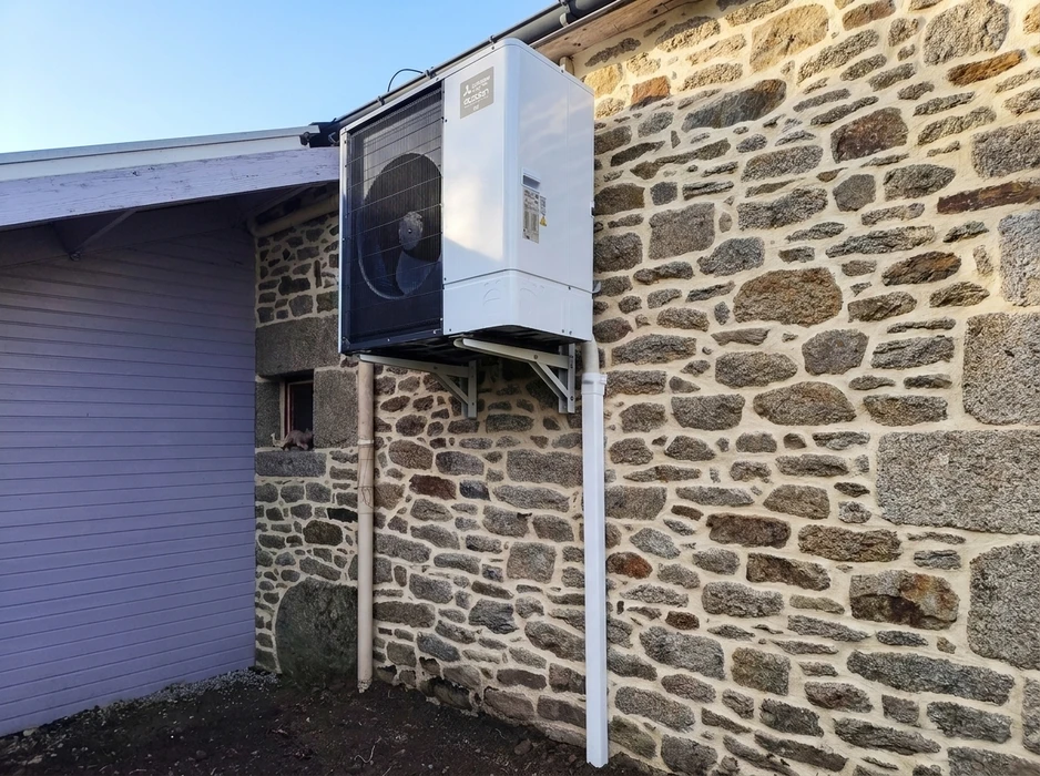 Unité extérieure de pompe à chaleur air/eau Mitsubishi Electric Ecodan, montée en hauteur sur support mural métallique fixé sur façade en pierre de granite